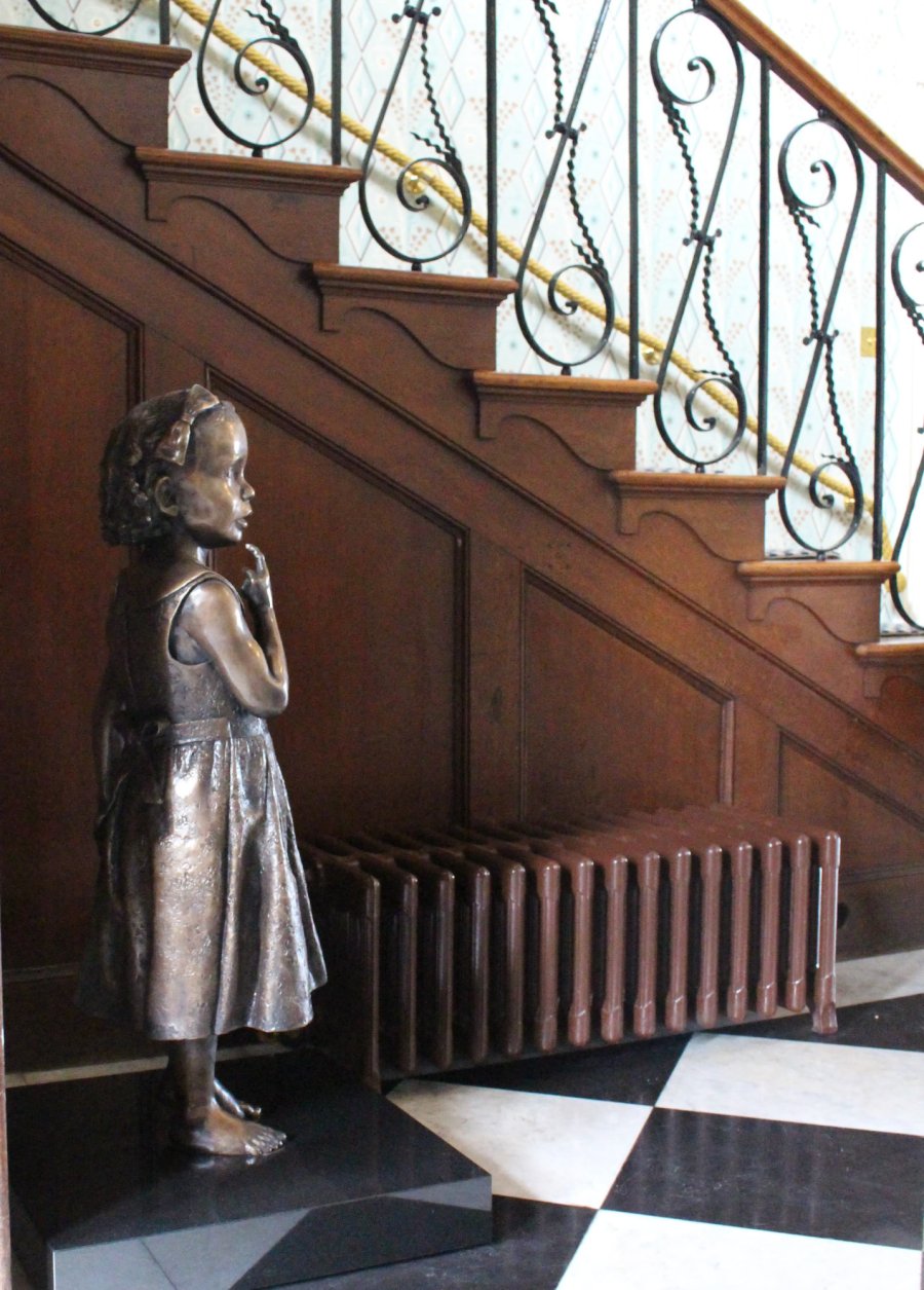 Bronze statue of a sister by a staircase